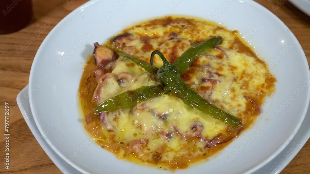 octopus soup with cheese and chili garnished, tomato soup, the plate which rotates for your delight octopus soup with cheese and chili garnished, tomato soup, the plate which rotates for your delight