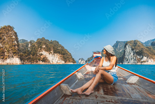 Traveler asian woman relax and travel on Thai longtail boat in Ratchaprapha Dam at Khao Sok National Park Surat Thani Thailand