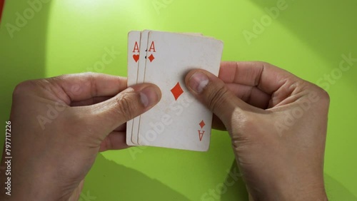 Closeup of a hand holding playing cards and looking at them photo