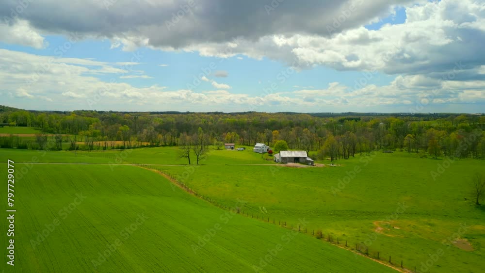 Aerial drone view of countryside home with beautiful blue sky and clouds and lush green grass. Aerial drone view of countryside home with beautiful blue sky and clouds and lush green grass.