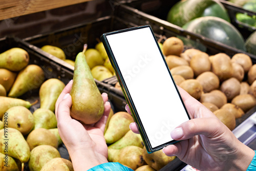 Pear fruit in hand and smartphone