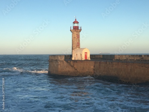 Felgueiras Lighthouse on the stone pier against the backdrop of a blue sky. Porto, Portugal photo