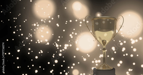 Image of a gloden cup over white shapes floating on black background with white lights