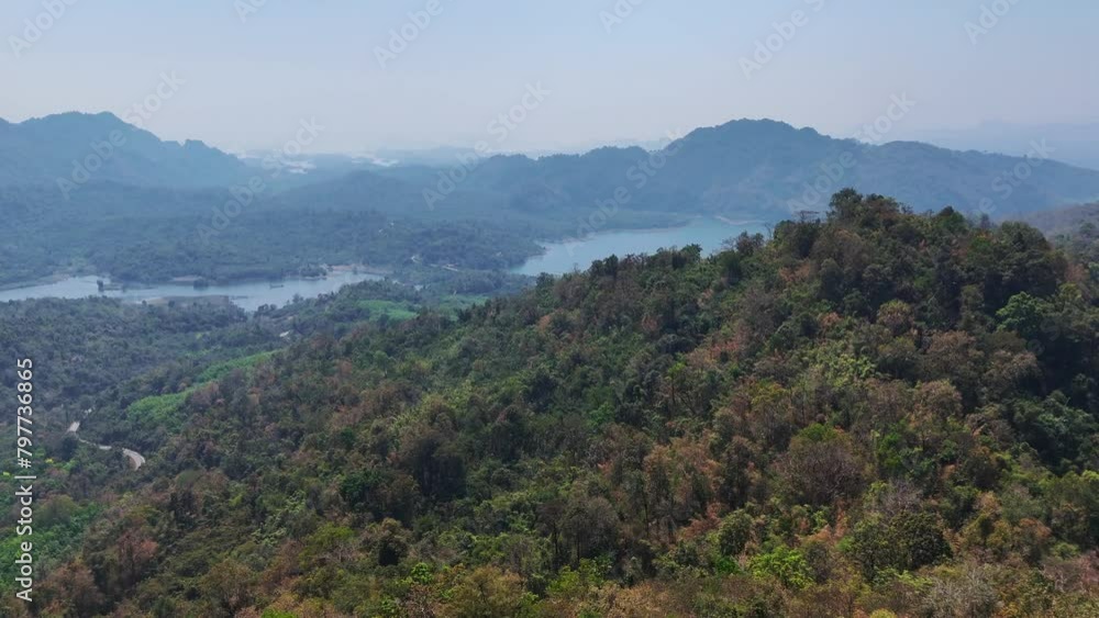 A bird's-eye view of mountains and jungle in Khao Laem National Park, Songklaburi, Thailand, showcasing the natural beauty of the region. A bird's-eye view of mountains and jungle in Khao Laem National Park, Songklaburi, Thailand, showcasing the natural beauty of the region.