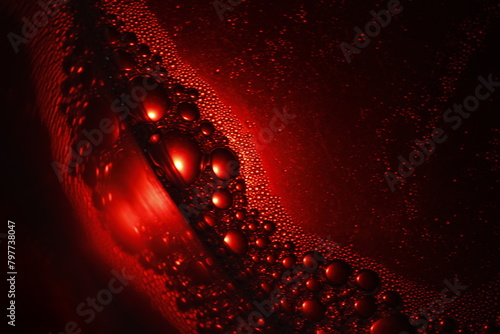 Burbujas de color rojo sobre el círculo de cristal con agua y jabón, flotan en la superficie líquida formando un original diseño abstracto para fondos exclusivos. photo