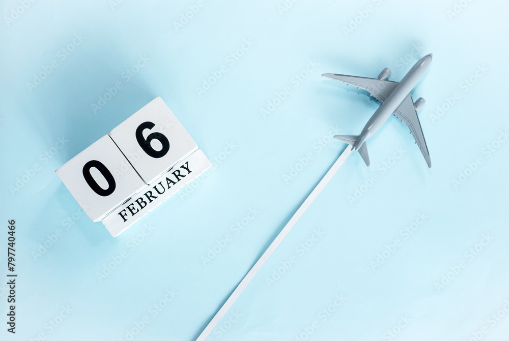 February calendar with number 6. Top view of calendar with flying passenger plane. Scheduler. Travel concept. Copy space. February calendar with number 6. Top view of calendar with flying passenger plane. Scheduler. Travel concept. Copy space.