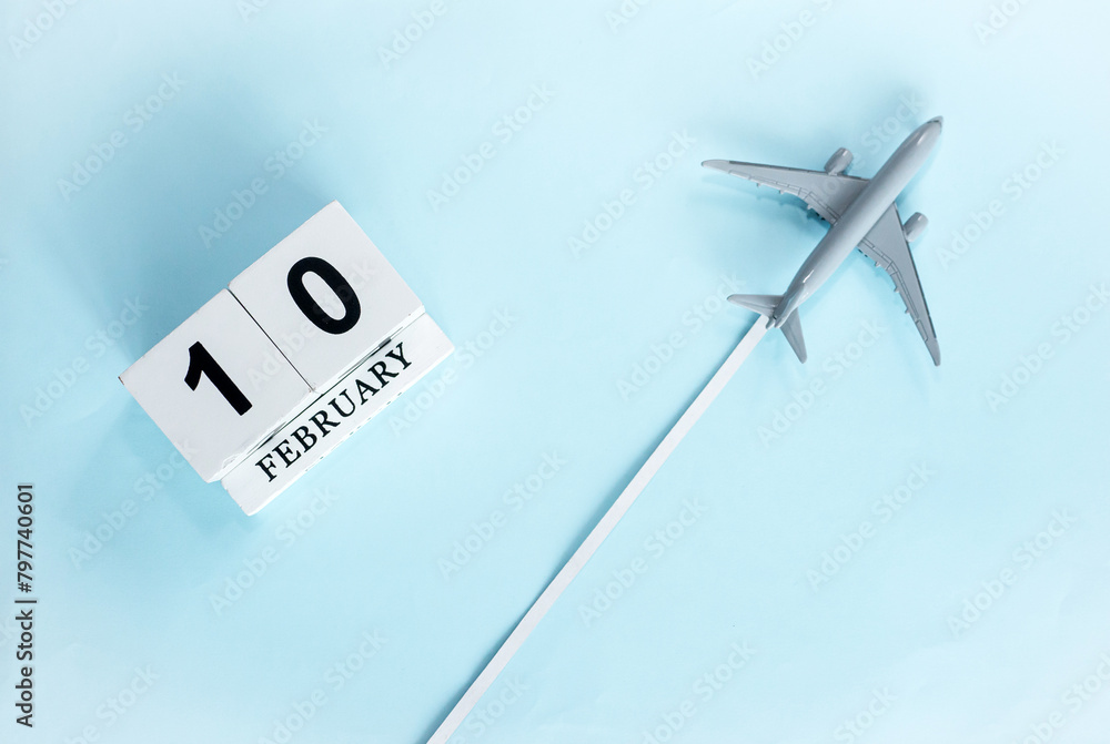 February calendar with number 10. Top view of calendar with flying passenger plane. Scheduler. Travel concept. Copy space. February calendar with number 10. Top view of calendar with flying passenger plane. Scheduler. Travel concept. Copy space.