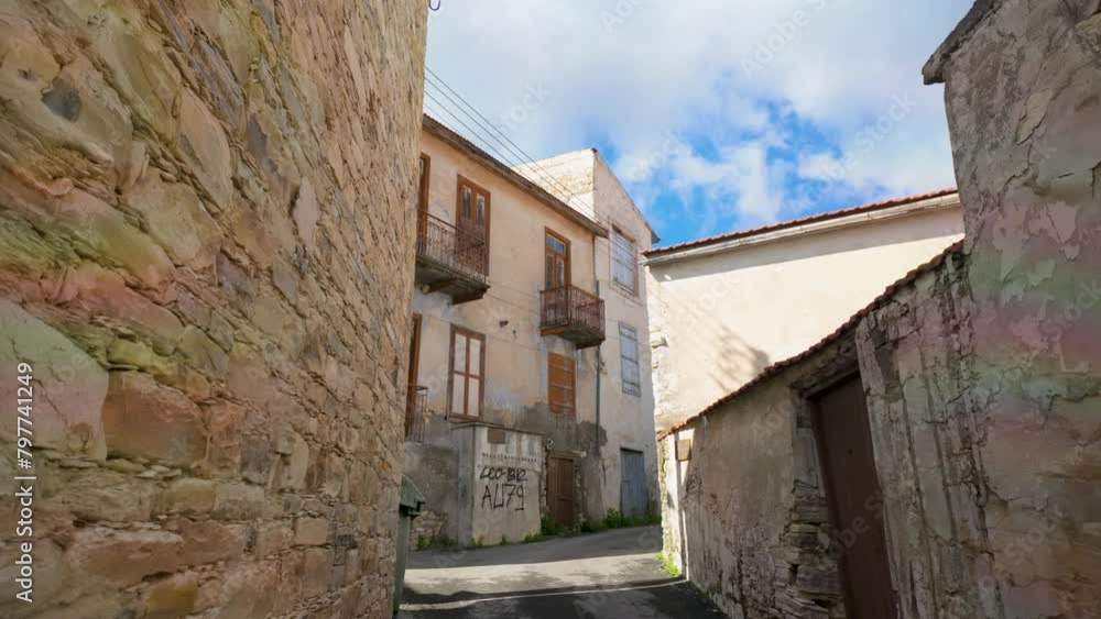 Narrow village alley between aged stone walls leading to traditional buildings under a clear sky, indicative of Lefkara's rustic charm. Narrow village alley between aged stone walls leading to traditional buildings under a clear sky, indicative of Lefkara's rustic charm.