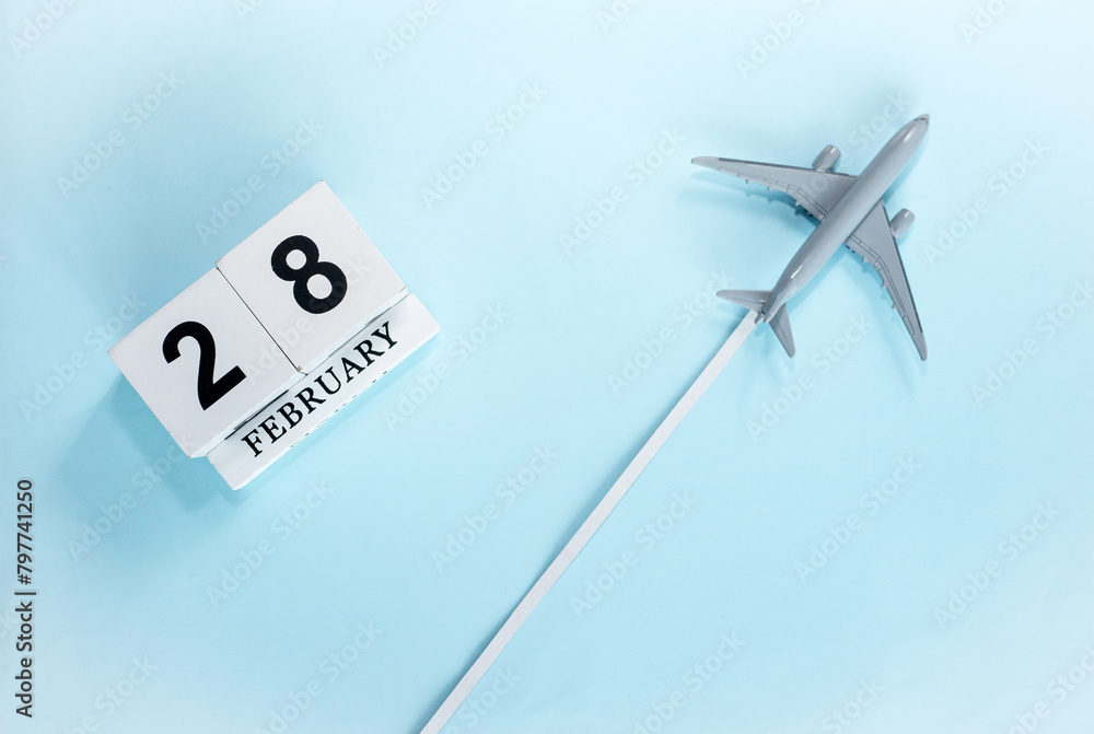 February calendar with number 28. Top view of calendar with flying passenger plane. Scheduler. Travel concept. Copy space. February calendar with number 28. Top view of calendar with flying passenger plane. Scheduler. Travel concept. Copy space.