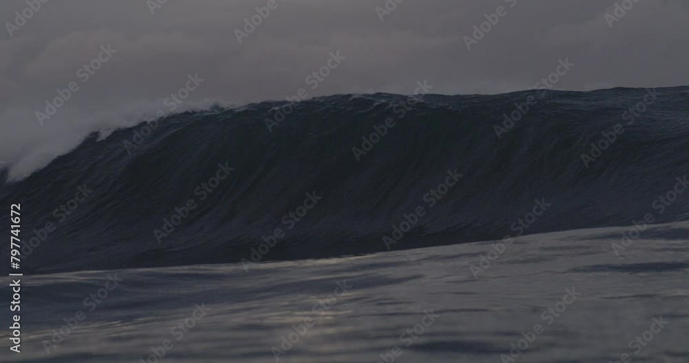 Steep wave rises up into wall of water crashing making a deep barrel