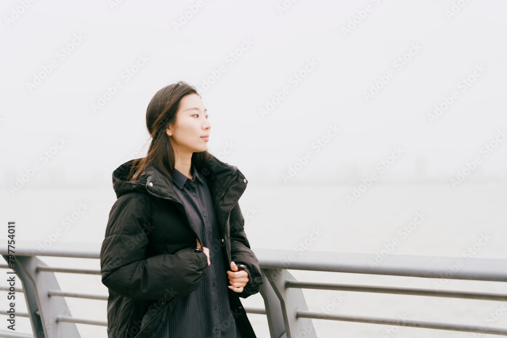 On cloudy winter days, Asian women walk along the seaside boardwalk On cloudy winter days, Asian women walk along the seaside boardwalk