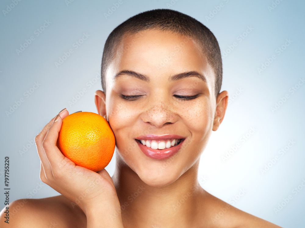 Skincare, beauty and woman with orange in studio for natural, organic and facial treatment. Wellness, health and model with citrus fruit with vitamin c for face dermatology routine by gray background Skincare, beauty and woman with orange in studio for natural, organic and facial treatment. Wellness, health and model with citrus fruit with vitamin c for face dermatology routine by gray background