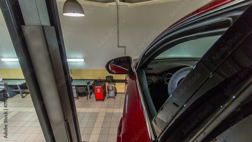 Car mechanic drive red car from lift to wheels alignment camber check at repair service station timelapse