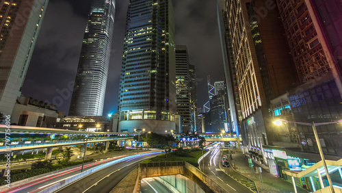 Hong Kong Business District with busy traffic timelapse at night. photo