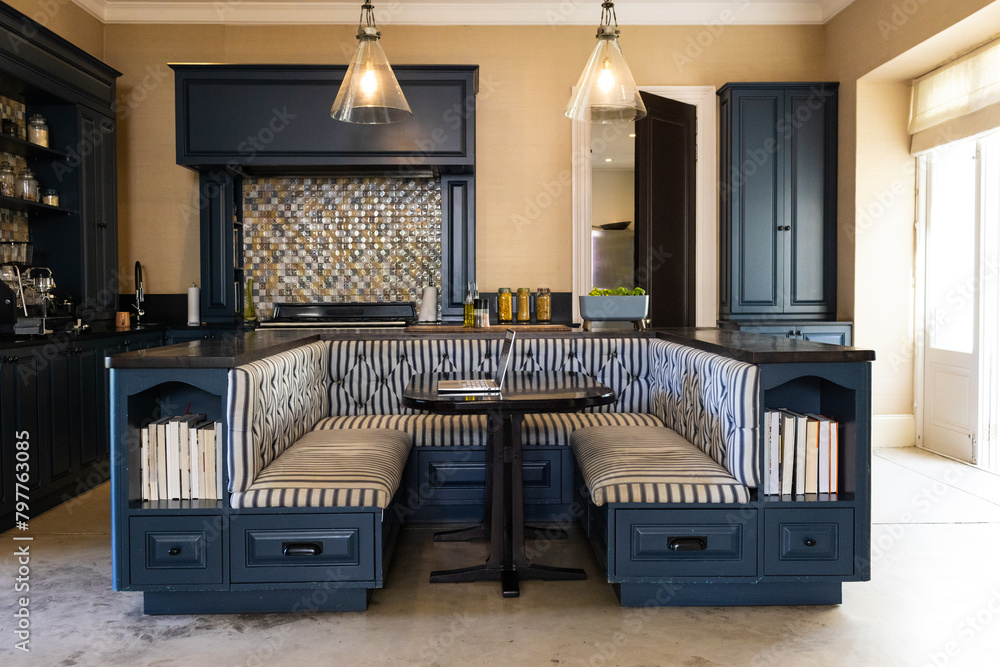 © Wavebreak Media - A modern kitchen with dark cabinets and cozy booth-style seating area