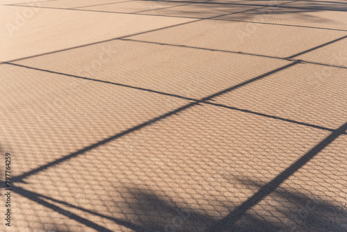 shadows of a barrier fence on a baseball infield © eugen