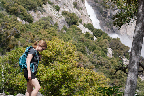 Hiker immersed in wilderness near Hetch Hetchy waterfall, immers