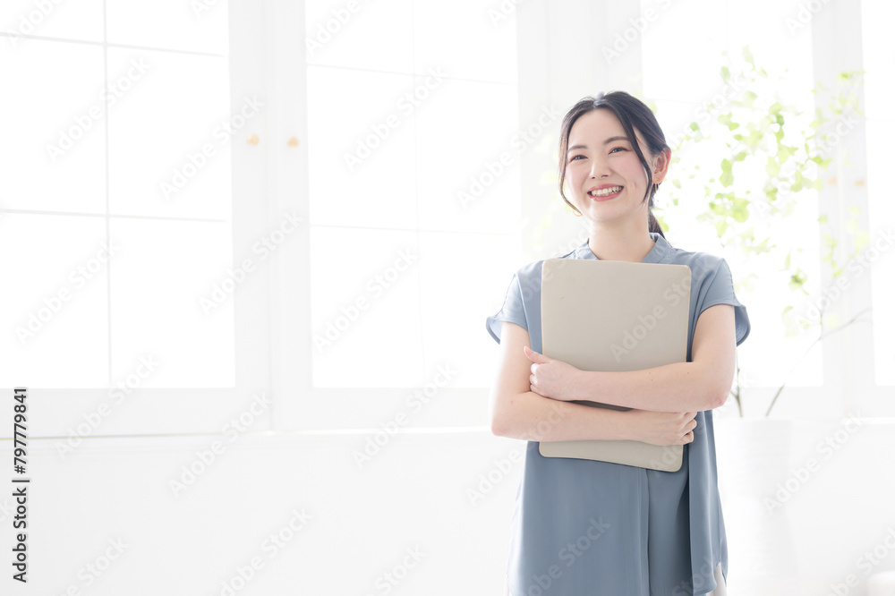 Beautiful woman with laptop in beautiful office window Looking up holding computer Beautiful woman with laptop in beautiful office window Looking up holding computer