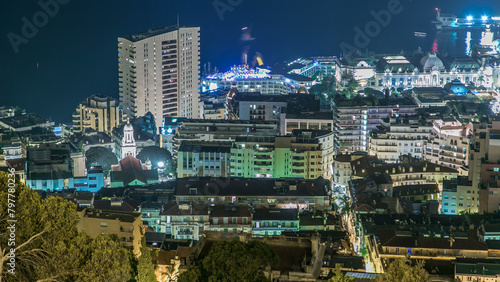 Cityscape of Monte Carlo, Monaco night timelapse with roofs of buildings and traffic on roads.