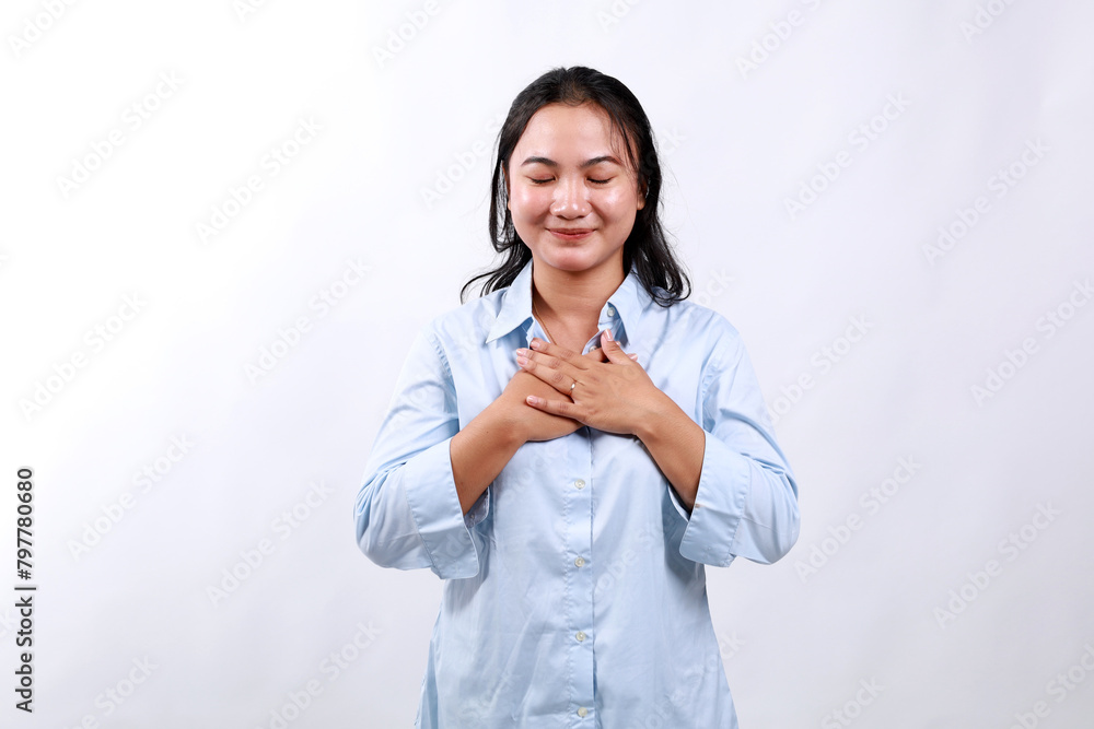 Asian business woman smiling with hands on chest with closed eyes and grateful gesture over white background, feels relieved Asian business woman smiling with hands on chest with closed eyes and grateful gesture over white background, feels relieved