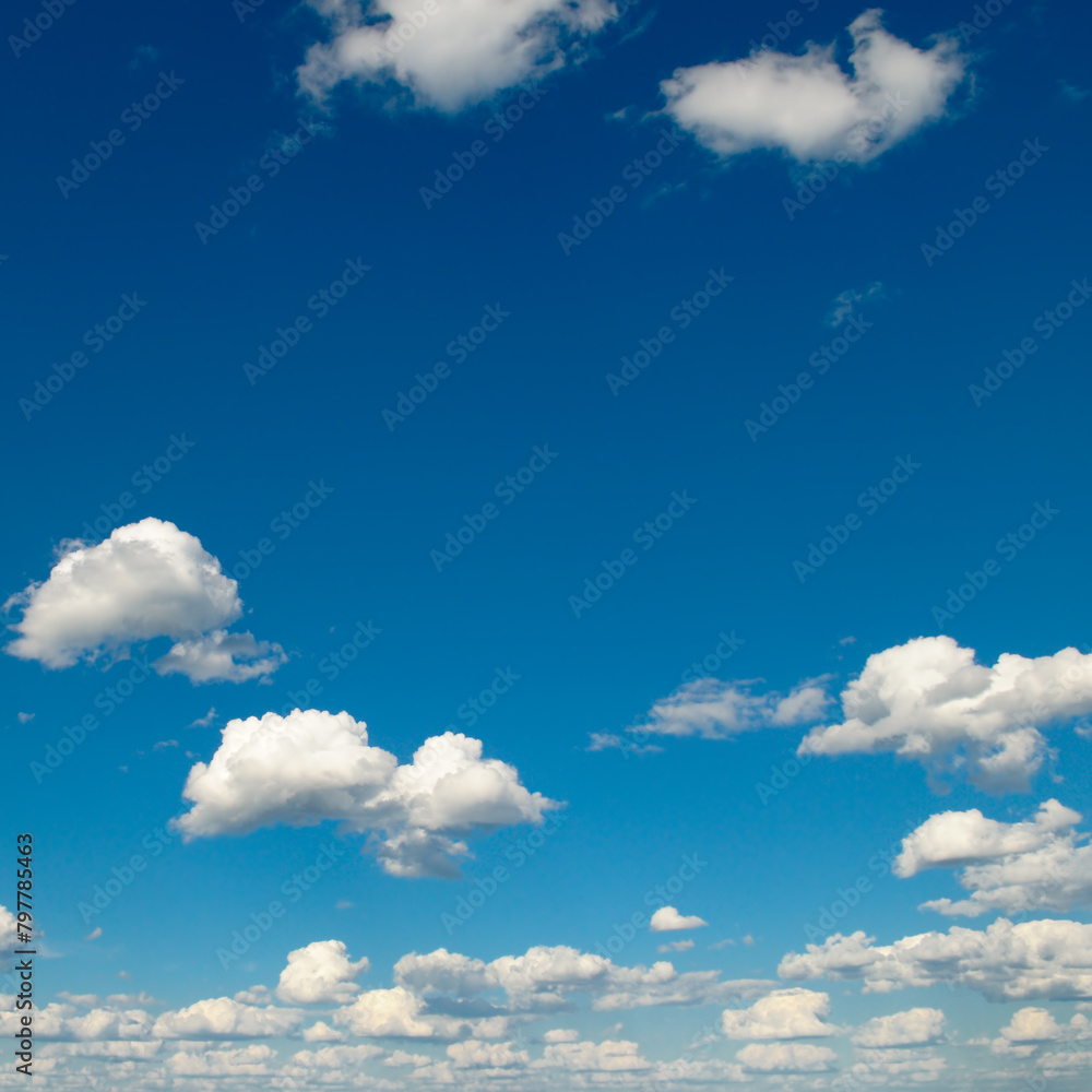 White fluffy clouds and sun on dark blue sky. White fluffy clouds and sun on dark blue sky.