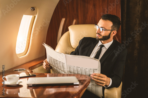 Fototapeta Businessman wearing corporate business suit flying on luxury private jet, concep