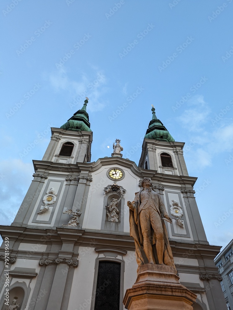 Mariahilf Church and Josef Haydn Statue and Moon in the Sky at Mariahilfer Strasse in Vienna Austria