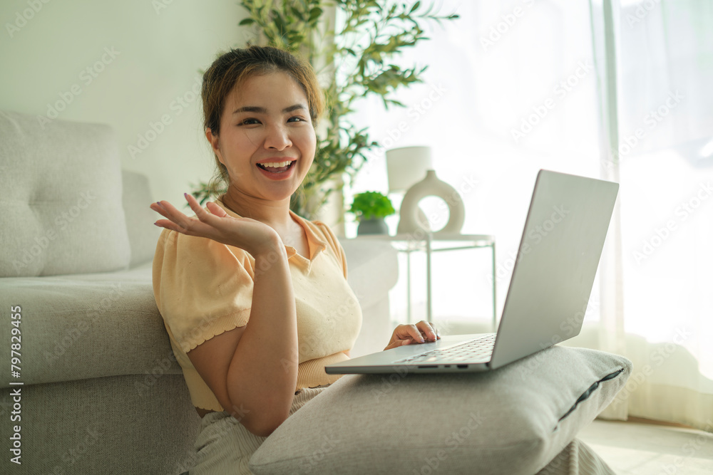 Cheerful young woman using laptop on floor in living room. Cheerful young woman using laptop on floor in living room.