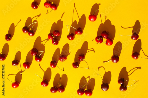 Cherry berries on a yellow background with contrasting shadows. Summer concept