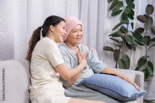 Happy senior woman with breast cancer after chemotherapy spend free time with daughter, elderly retirement mom talking to young female caregiver or hiring occupational nurse caregiving at home