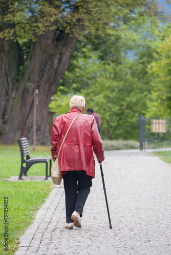 An elderly woman walks with a cane. © Jacek