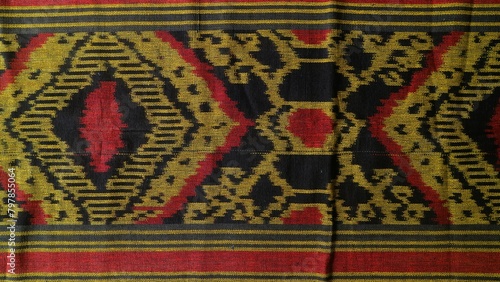 Handmade woven textile with unique pattern from Indonesia, close up textured multicolor fabric background, traditional clothing in southeast asia