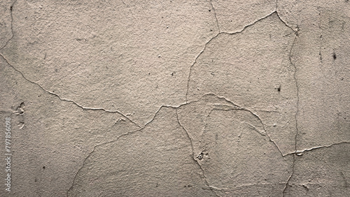 Grunge background of shabby wall with cracked paint layer. Backdrop with copy space for design. Brown wallpaper of concrete surface. Film grain texture. Soft focus. Blur