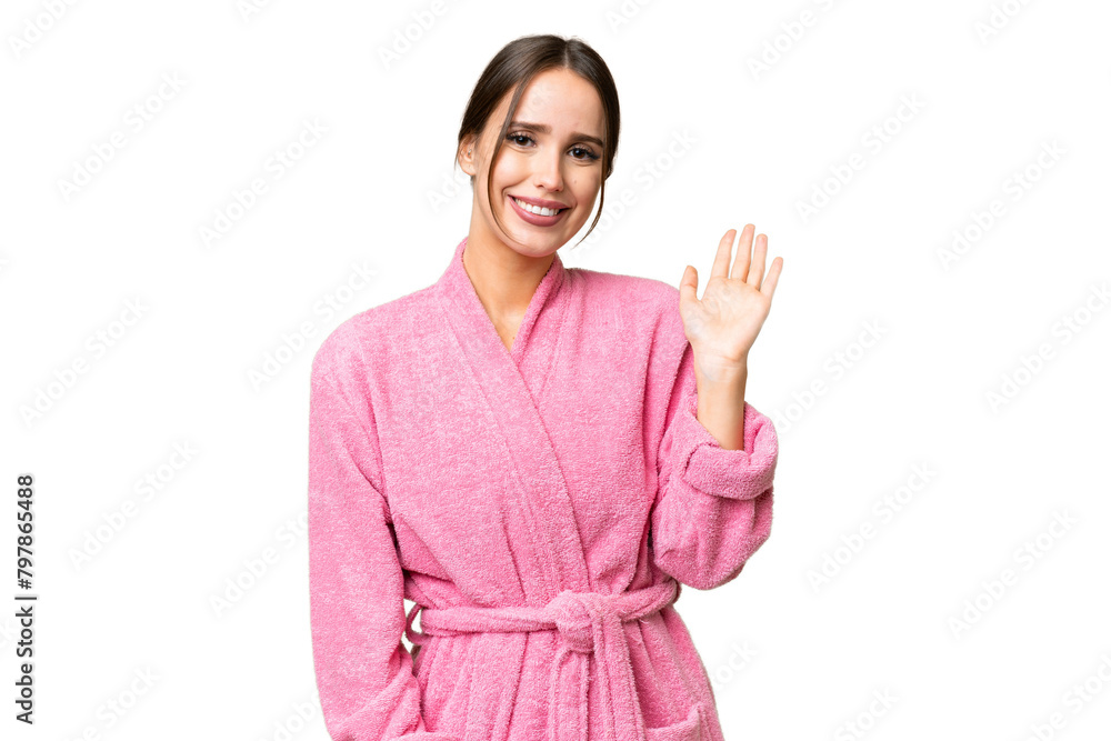 Young beautiful woman in a bathrobe over isolated chroma key background saluting with hand with happy expression Young beautiful woman in a bathrobe over isolated chroma key background saluting with hand with happy expression