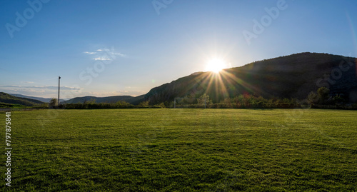 Football field with green grass at sunny day. Soccer field in the rural. Soccer field in the countryside. 