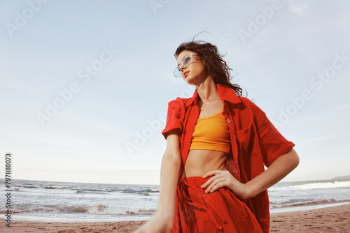 A Carefree Portrait of a Smiling Woman at the Beach, Enjoying the Vibrant Sunset and the Freedom of the Ocean © SHOTPRIME STUDIO