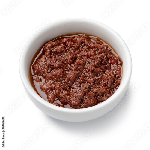White bowl with traditional homemade black olive tapenade isolated on white background close up