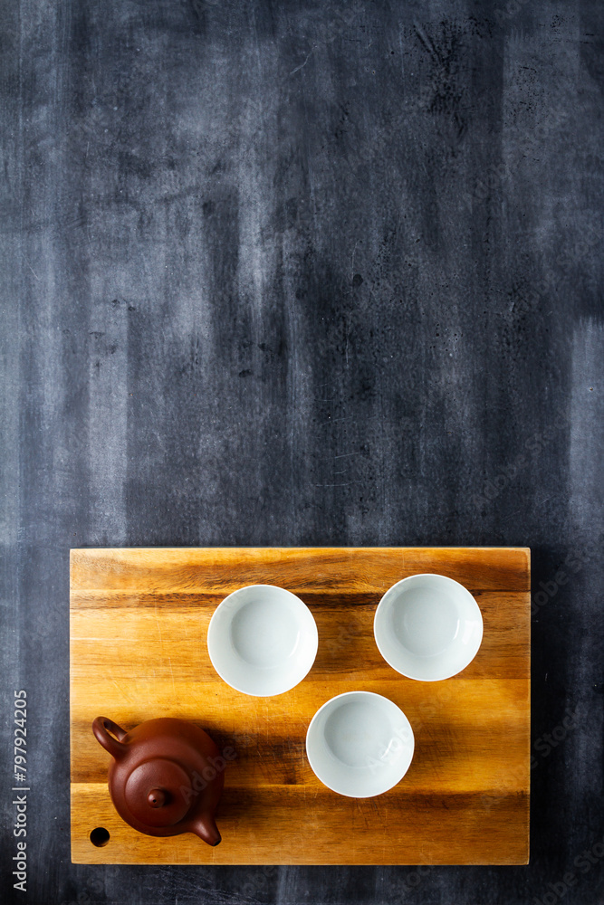 Teapot and cups on wooden cutting board Teapot and cups on wooden cutting board