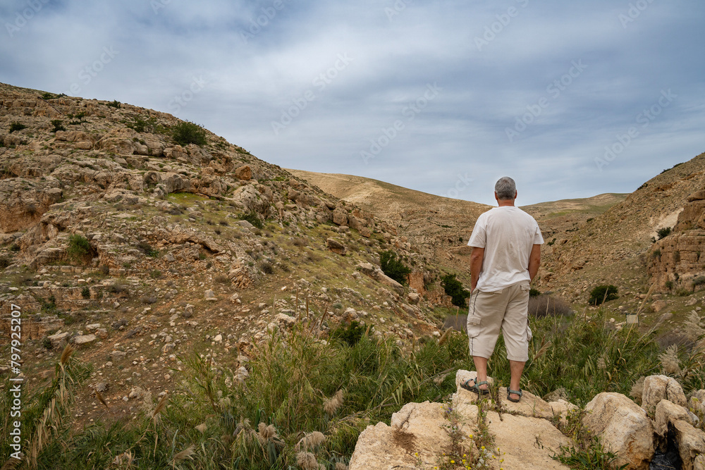 A Hiker on a Cliff Overlooking the Prat Stream, Israel A Hiker on a Cliff Overlooking the Prat Stream, Israel