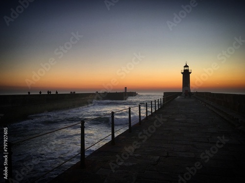 Sunset at the ocean pier with a Farol de Felgueiras lighthouse in Foz do Douro, Porto, Portugal, January 2019 photo