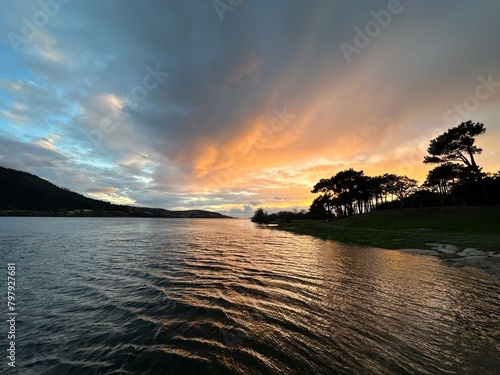 River Minho with the trees on the shore during colorful sunset near Eiras, O Rosal, Galicia, Spain, February 2023 photo
