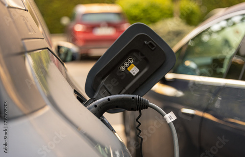 Electrical cars charging station. Close up photo with a high power socket attached to an electrical car while charging. Electric cars industry.
