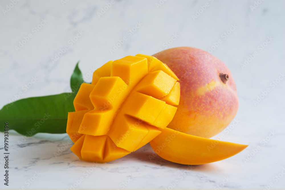 Ripe mango fruit and mango slice on marble background