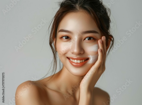 b'Asian woman applying facial powder'