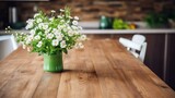 b'A beautiful bouquet of white daisies in a green vase sits on a wood table.'
