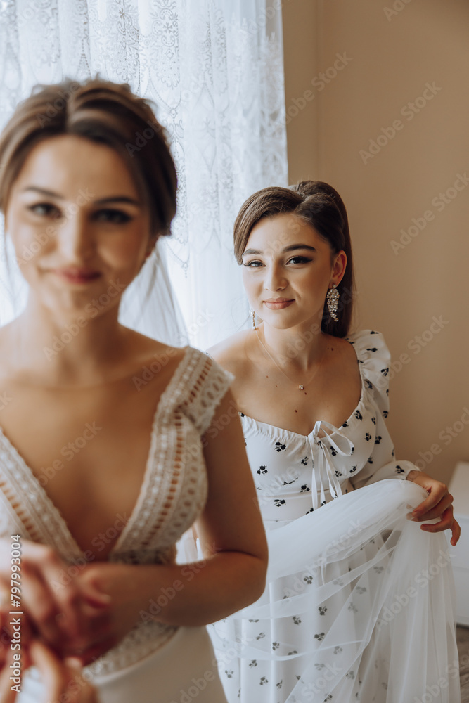 Two women are standing in front of a window Two women are standing in front of a window