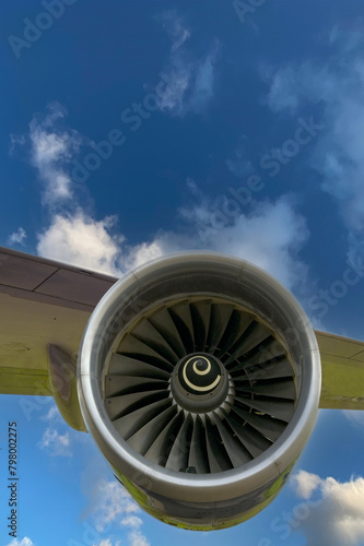 Jet turbofan engine and aircraft wing isolated against a blue sky. Travel concept.