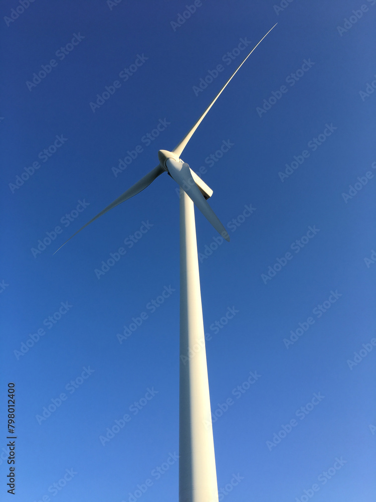 detail of sustainable energy wind turbine, with light blue background, vertical image detail of sustainable energy wind turbine, with light blue background, vertical image