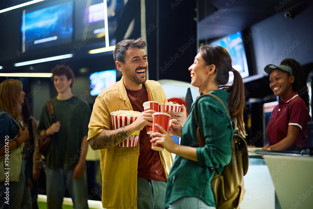 Fototapeta premium Cheerful couple having fun before movie projection in cinema.