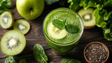 Blended green smoothie with ingredients on wooden table.